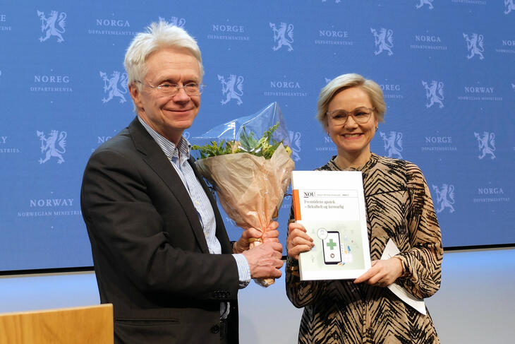 Leader of the committee on pharmacy law, Tore Bråthen, delivers the report to the Minister of Health and Care services, Ingvild Kjerkol. (Hanne Nessing)